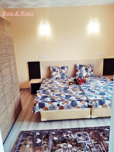 a bedroom with a bed with a blue and white comforter at Rose & Water Guest house in Pavel Banya
