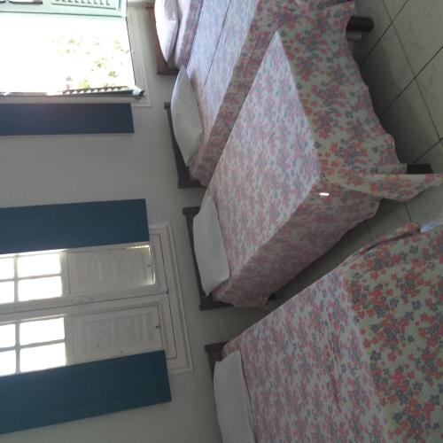 a bedroom with two beds with pillows and a window at Hotel Central in Recife