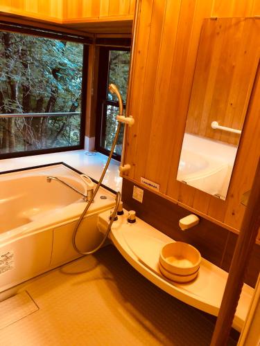 a bathroom with a toilet and a bath tub at 大人スイート 那須高原 結 cottage in Nasu