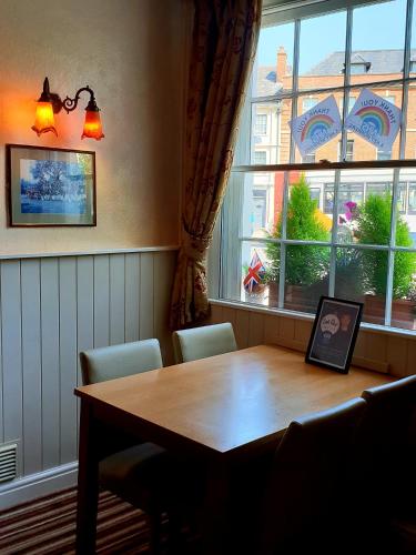 a dining room table with chairs and a large window at The Pelican Inn in Devizes