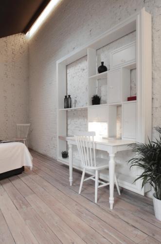 a white dining room with a white table and chairs at Maison Nationale City Flats & Suites in Antwerp
