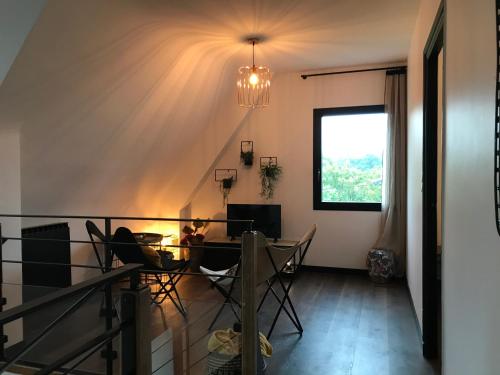 une salle à manger avec une table et des chaises et une fenêtre dans l'établissement Ty Kervaillet,Maison rénovée proche plage, à Névez