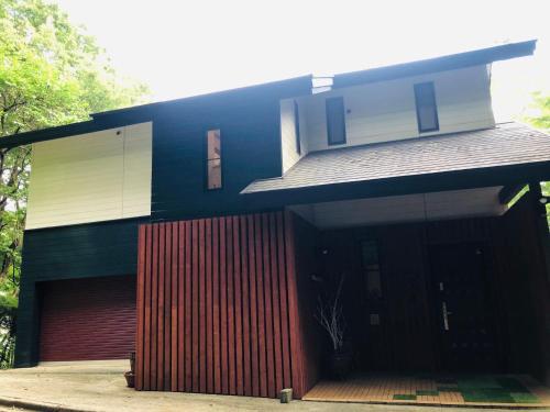 a house with a red door in front of it at 大人スイート 那須高原 結 cottage in Nasu