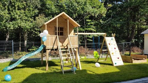 une aire de jeux avec un toboggan et une maison de jeux dans l'établissement Widokowo - Domki z widokiem na Śnieżkę z Jacuzzi i Sauną, à Karpacz