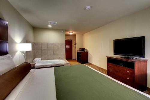 a hotel room with a bed and a flat screen tv at Cobblestone Inn & Suites - Carrington in Carrington