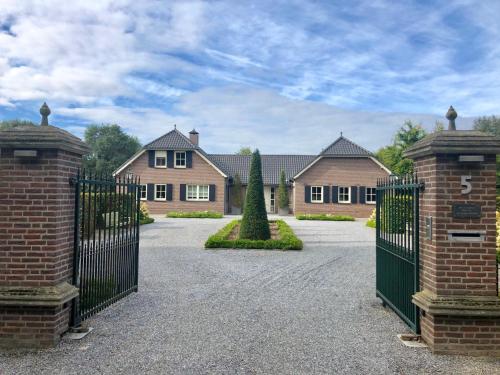 a large house with a gate in front of it at Landhuis Hotel de Hilkensberg in Broekhuizen
