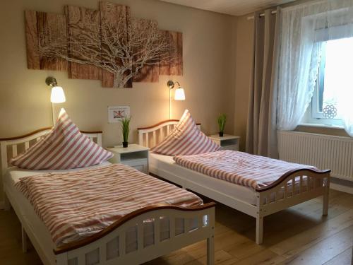 - 2 lits dans une chambre avec fenêtre dans l'établissement Palminas Ferienwohnung OG, à Merzig
