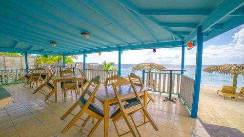a restaurant with tables and chairs on the beach at Tamboo Resort in Negril