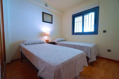 two beds in a room with a window at Apartment Bleakley in Altea