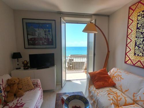 a living room with a couch and a view of the ocean at Rosso Tramonto luxury-white- LADISPOLI, Lungomare Regina Elena 58 in Ladispoli