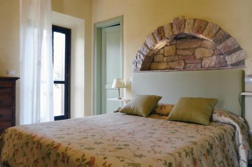 una camera da letto con un grande letto e un muro in pietra di Tenuta Agricola dell'Uccellina a Talamone