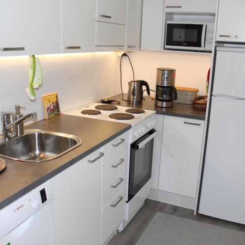 a kitchen with a sink and a stove top oven at Bright star apartament Siilinjärvi in Siilinjärvi