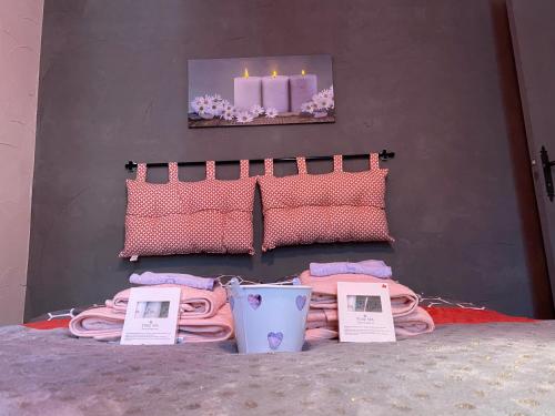 a bedroom with pink pillows and a bed with price signs at La Cigale in Annot