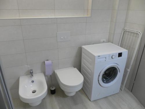 a bathroom with a washing machine and a toilet at La casa di Virginia in Arco