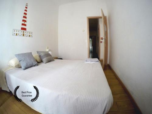 um quarto com uma grande cama branca com almofadas azuis em Aveiro Guest House em Aveiro