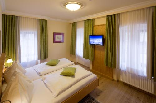 a hotel room with two beds and a television at Hotel Zum Schwarzen Bären in Emmersdorf an der Donau