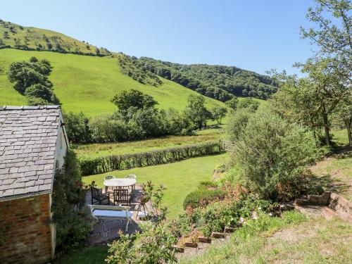a view of a garden with a table and chairs at Dolgenau Hir - The Barn in Trefeglwys