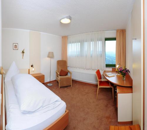 a hotel room with a bed and a desk at Haus Maria Lindenberg in Sankt Peter