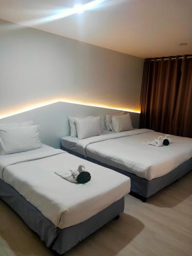 two beds with stuffed animals on them in a room at Bed By Boat @Nonthaburi Pier in Nonthaburi