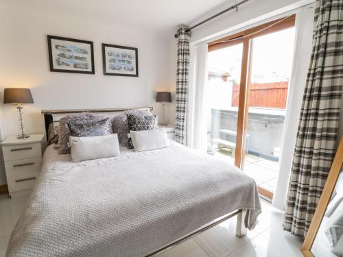 a bedroom with a bed and a large window at Smithy Cottage in Cemaes Bay