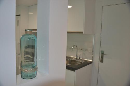 a glass bottle sitting on a counter next to a sink at La Perla de Sunset Beach in Corralejo