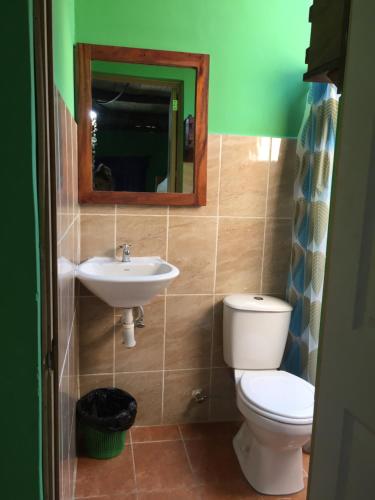 a bathroom with a toilet and a sink and a mirror at Sunrise El Paredón in El Paredón Buena Vista