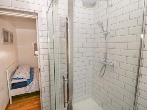 una doccia con una porta in vetro in un bagno di Buarthau Cottage a Caernarfon