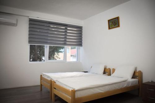 a bedroom with a bed and a window with blinds at Vila Oska in Vinica