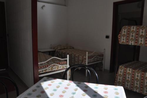 a room with three beds and a table and chairs at Camping Villaggio Paradiso in Domaso
