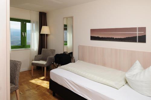 a hotel room with a bed and a chair at Haus Maria Lindenberg in Sankt Peter