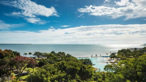 a view of a beach and the ocean with trees at Oaks Cairns Hotel in Cairns