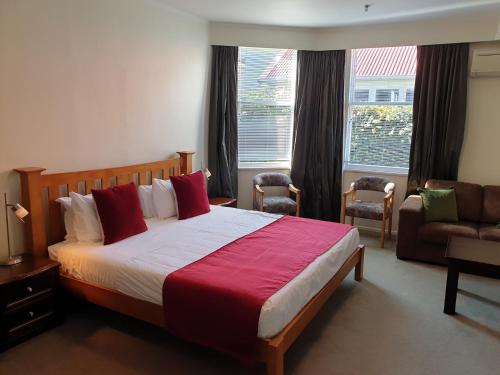 sypialnia z łóżkiem, kanapą i oknem w obiekcie At Eden Park Motel w Auckland