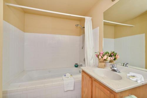 a bathroom with a sink and a bath tub at Americas Best Value Inn Lakewood South Tacoma in Lakewood