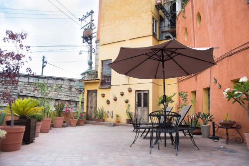 a patio with a table and an umbrella at Lofts Las Cuatro Puertas in Guanajuato