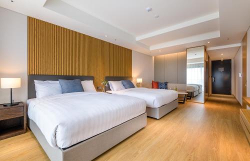 a hotel room with two beds and a couch at The Grand Sumorum in Seogwipo