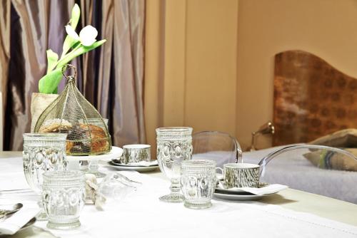 a table with glasses and a bird cage on it at Petite Suite in Bergamo