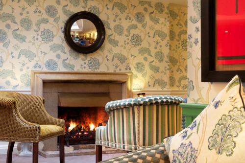 a living room with a fireplace and a couch and a mirror at Mercure Salisbury White Hart Hotel & Apartments in Salisbury