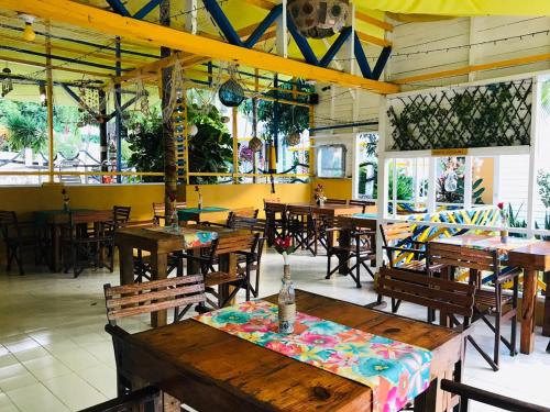 a restaurant with wooden tables and wooden chairs and tables at Cabañas Agua Dulce in Providencia