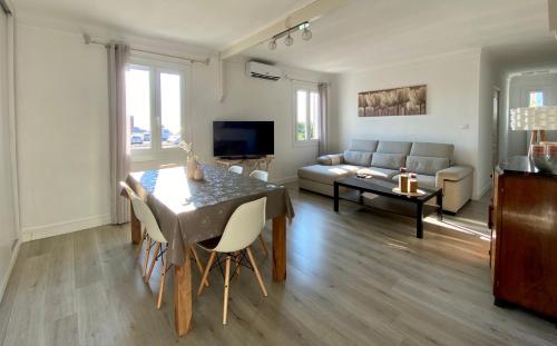 a living room with a table and a couch at Magnifique appartement devant la plage in Propriano