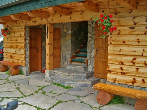 a log cabin with a staircase and a bench at Penzion a drevenica pri Hati in Terchová