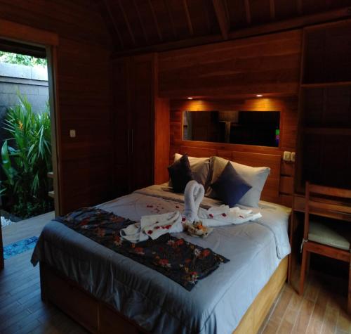 Un dormitorio con una cama con toallas. en Villa Lumbung Amertha Sari, en Lovina