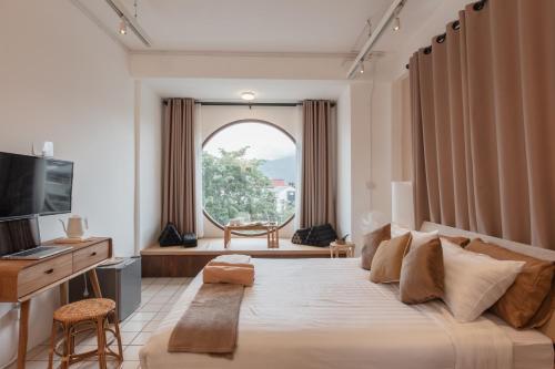 a bedroom with a large bed and a window at Muan Hotel in Chiang Mai