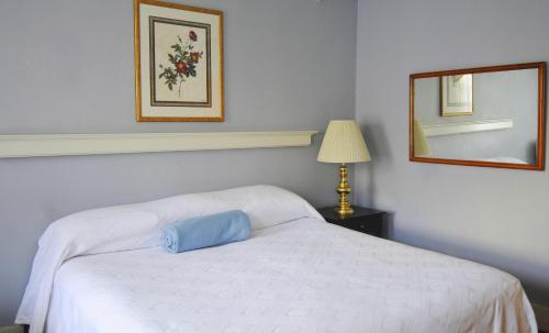 a bedroom with a white bed with a blue pillow on it at Hotel Coolidge in White River Junction