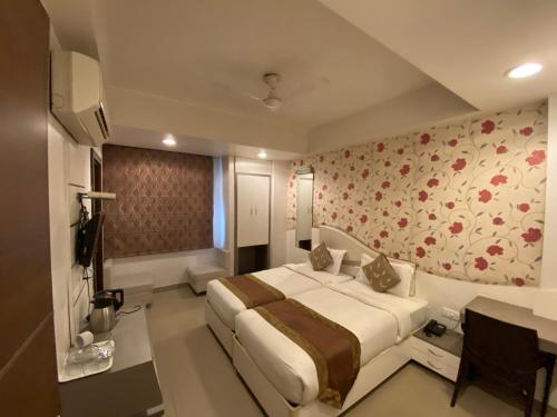 a bedroom with a large bed and floral wallpaper at Starlit Select Nirvana in Varanasi