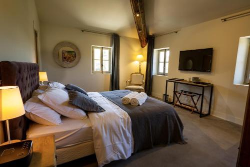 een slaapkamer met een bed met twee handdoeken erop bij Château les Gardis in Lourmarin