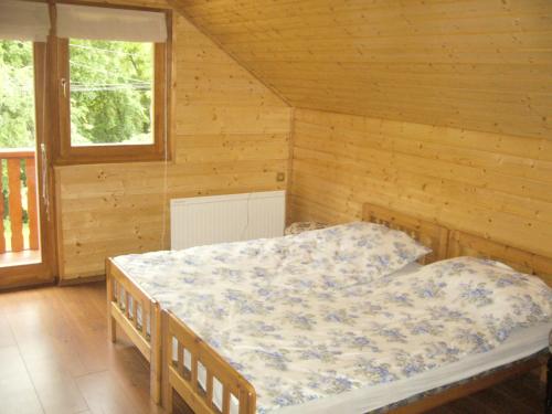 1 dormitorio con 1 cama en una habitación de madera en Béke Vendégház en Szada