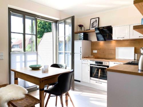 a kitchen with a table and chairs and a kitchen with white appliances at Zum Schwedenblick in Groß Kirr