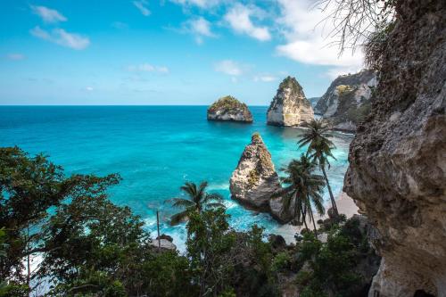 a view of a beach with rocks and the ocean at Abian Selumbung Bungalow in Nusa Penida