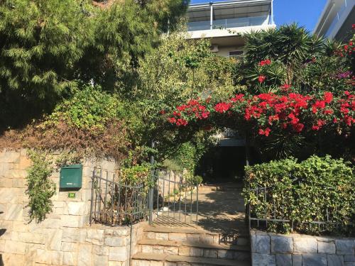 a garden with red flowers on a building at A1 Elegant Vouliagmeni apt in a Unique Spot in Athens