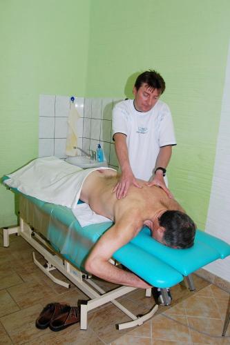 a man laying on a bed in a hospital at Lázeňský dům Erika in Františkovy Lázně